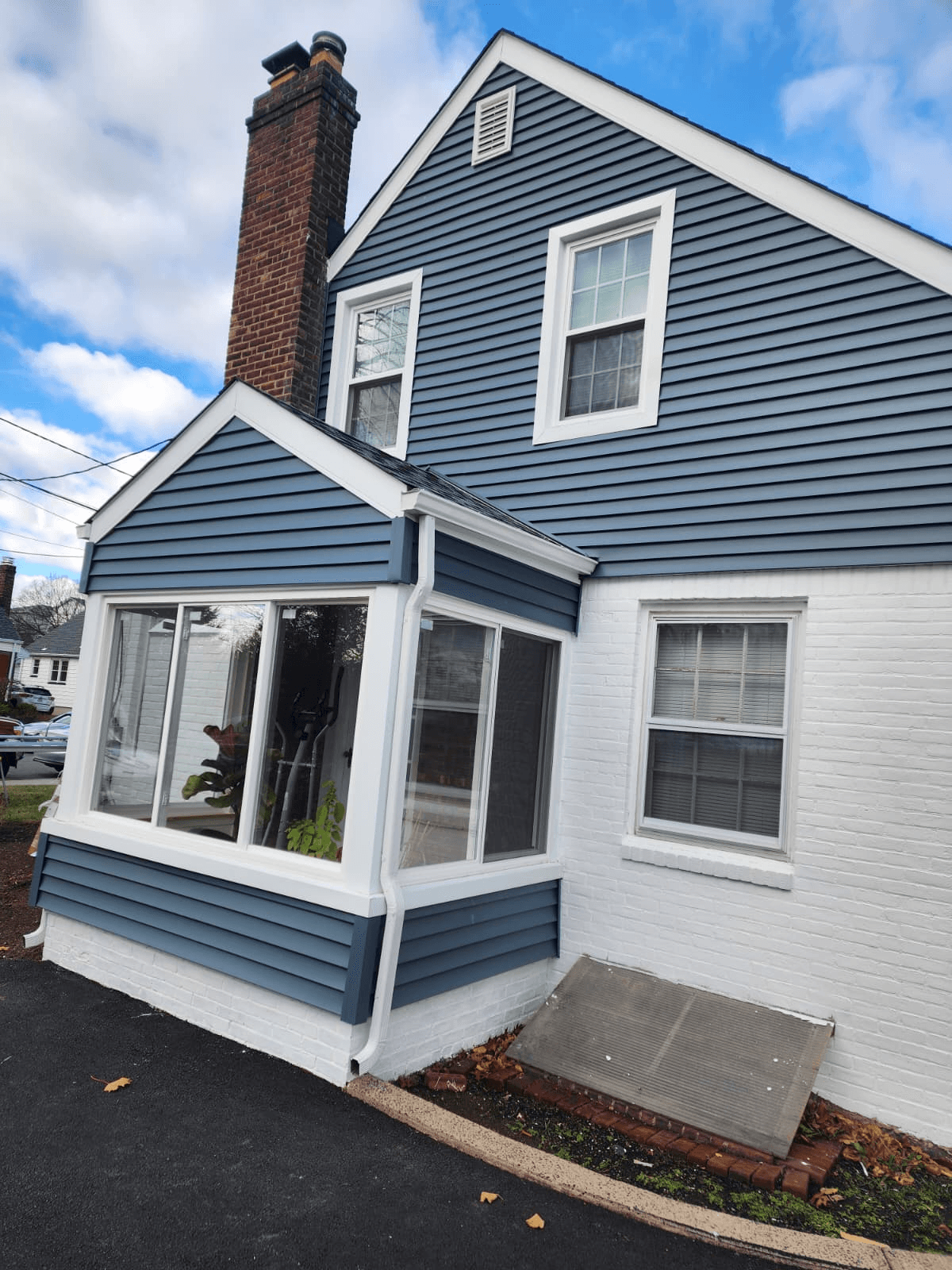 Completed job: slate-blue vinyl siding, white trim, new bay and double-hung windows on a North Jersey home